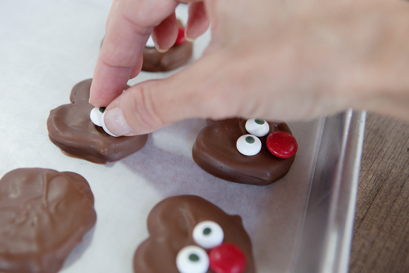 A cute and delicious treat to make with the kids this holiday season, these chocolate covered reindeer pretzels can be put together in no time at all!